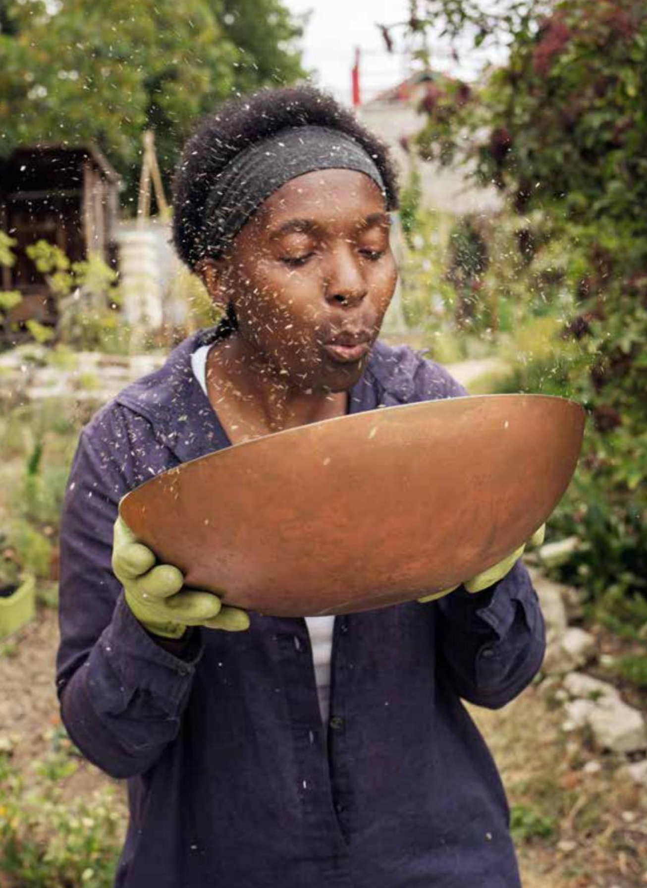Valéry Tsimba soufflant des graines dans son jardin