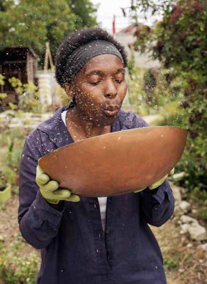 Valéry Tsimba soufflant des graines dans son jardin